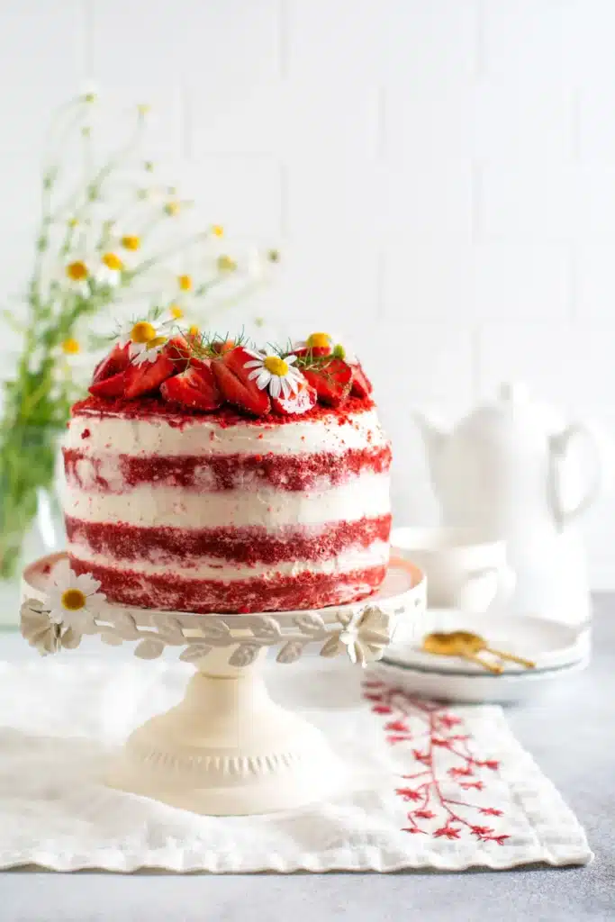Fraisier artisanal, gâteau à la génoise légère garni de crème et de fraises fraîches, décoré de fleurs comestibles, parfait pour une commande de pâtisserie personnalisée. 